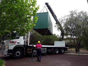 hiab lifting a container and man standing in front